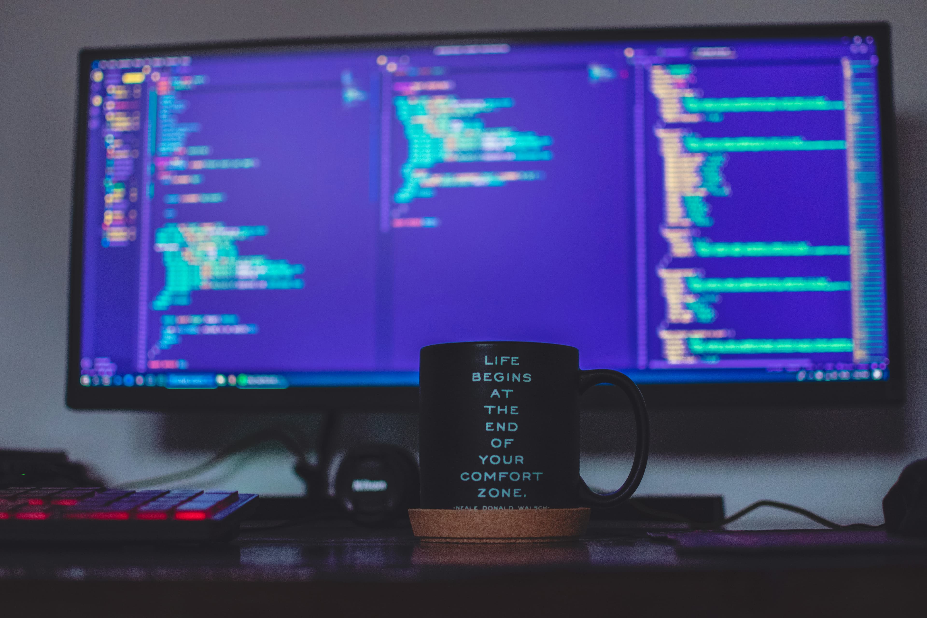 A desk with code on a monitor